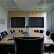 Conference room with two mounted displays and omnidirectional mic.