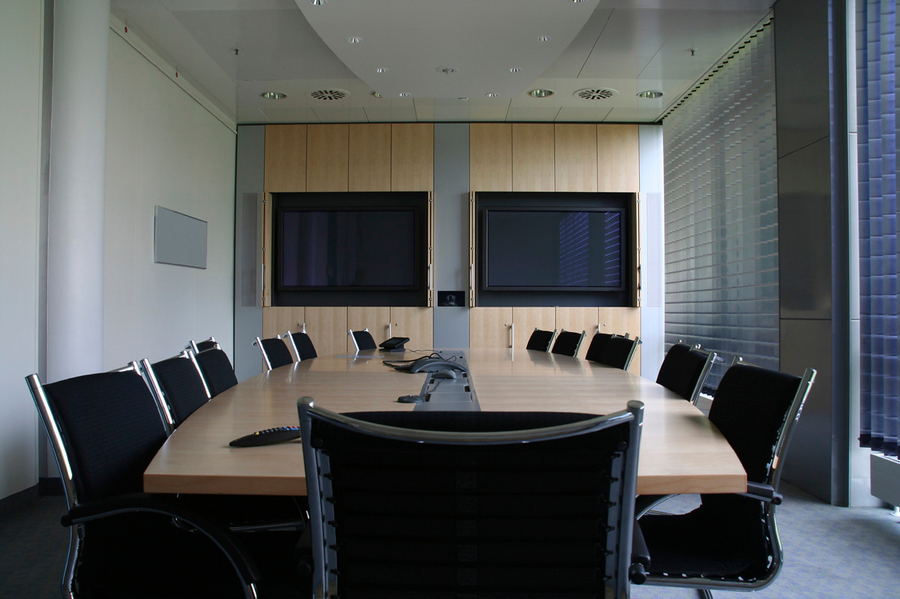 Conference room with two mounted displays and omnidirectional mic.