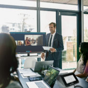 A group of people using a conference room display in a meeting room.