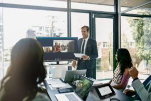 A group of people using a conference room display in a meeting room. 