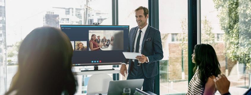 A group of people using a conference room display in a meeting room.
