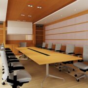 Empty conference room with a projector screen, chairs are slightly pulled out from underneath a long table