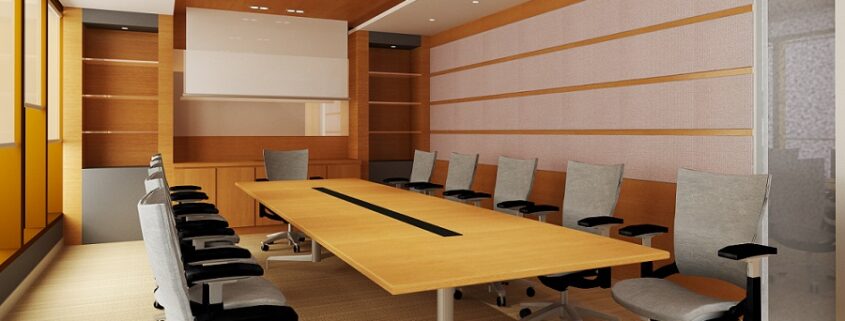 Empty conference room with a projector screen, chairs are slightly pulled out from underneath a long table
