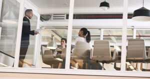 A group of people going over a presentation inside a corporate training room.