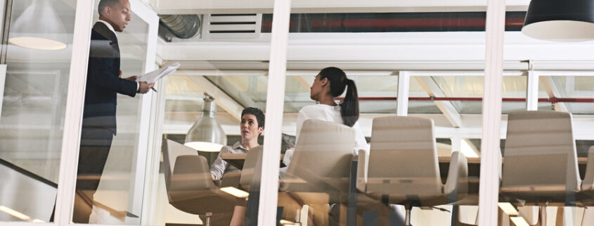 A group of people going over a presentation inside a corporate training room.