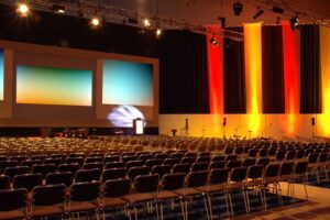 An auditorium’s AV system, including cameras, lights, and projector screens. 