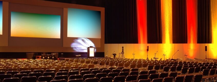 An auditorium’s AV system, including cameras, lights, and projector screens. 