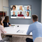A conference room meeting between on-site and remote employees. 