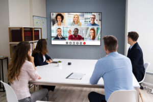 A conference room meeting between on-site and remote employees. 