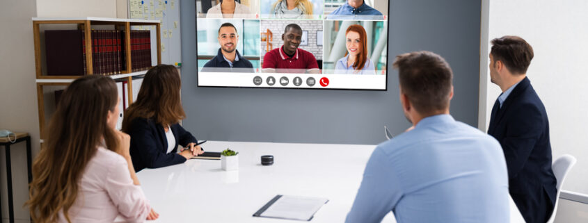 A conference room meeting between on-site and remote employees. 