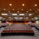 A large room designed for presentations. A projector hangs from the ceiling.