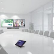 A large conference room with two video displays.