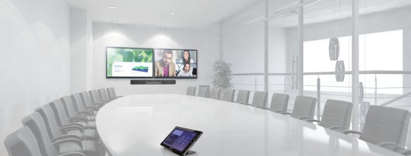 A large conference room with two video displays.