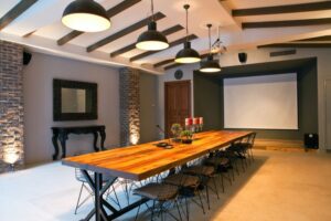 Beautiful conference room with a long table, chairs, and an interactive screen at the front of the room. 