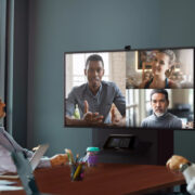 Group of people in a conference room taking part in a video call with Teams Rooms technology.