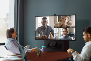 Group of people in a conference room taking part in a video call with Teams Rooms technology. 