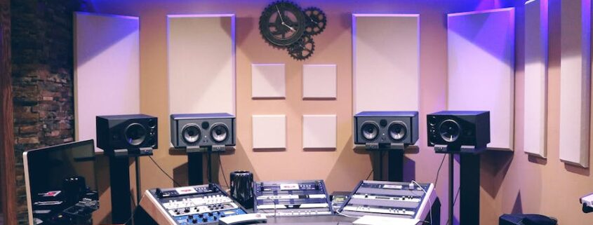 A modern recording studio illuminated by purple LED lights.