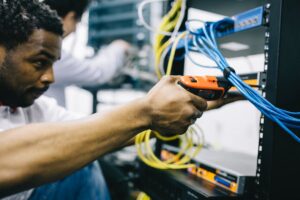 A technician giving maintenance to networking equipment.