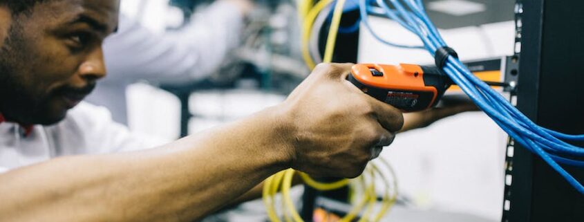 A technician giving maintenance to networking equipment.