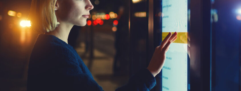 A woman interacting with a touch video wall.