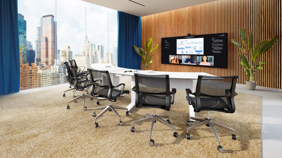 A modern conference room with a large display and skyscrapers in the distance.