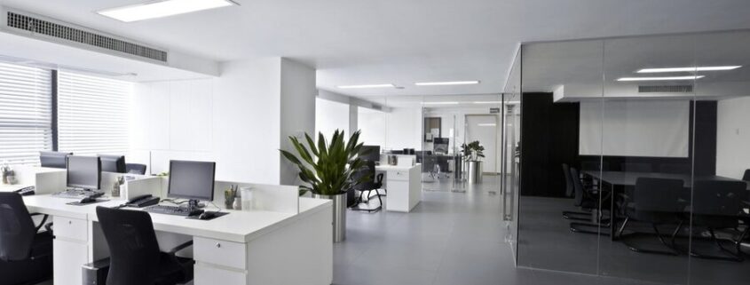 An open office space with several desks and a closed conference room in view.