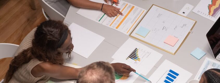 People gathered at a collaboration space with papers and laptops on the table.