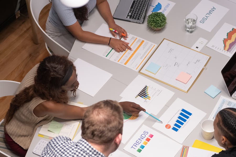 People gathered at a collaboration space with papers and laptops on the table.